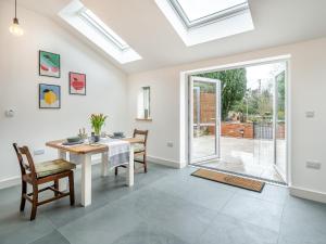 ein Esszimmer mit Tisch und Stühlen und einem Fenster in der Unterkunft Christopher's Cottage in Warcop