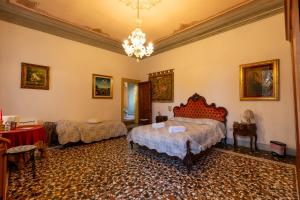 a bedroom with two beds and a chandelier at Villa Nani Mocenigo, Golin in Dolo
