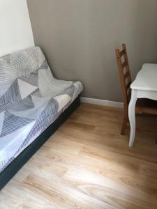 a bedroom with a bed and a table and a chair at Tranquille et chaleureux in Carcassonne