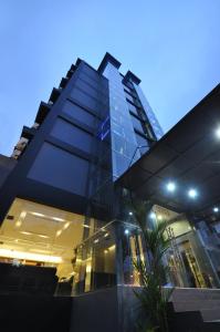 a large building with a glass facade at night at Dreamtel Jakarta in Jakarta