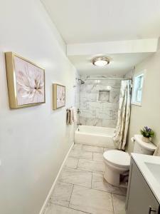 ein Badezimmer mit Toilette, Badewanne und Waschbecken in der Unterkunft Historic Barn View Modern Country Newton House in Newton