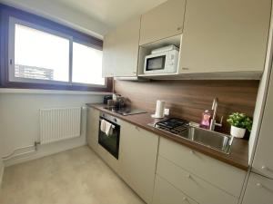 a kitchen with a sink and a microwave at Eiffel Tower View & Pool in Paris
