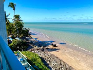 a view of the beach from the balcony of a resort at Flamboyant Oceania Flats in João Pessoa +22 photos