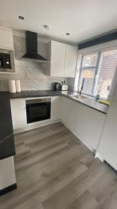 a kitchen with white cabinets and a sink at The Sauna House in Stockbury
