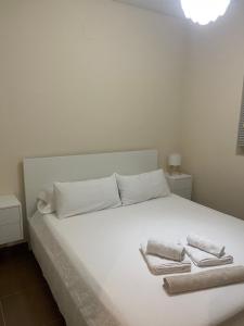 un letto bianco con due asciugamani sopra di Apartamentos Salma 20 a Toledo