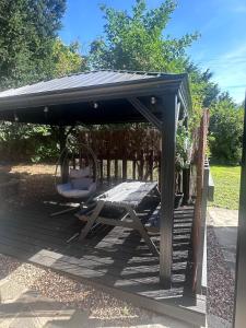 a gazebo with a swing and a chair at The Sauna House in Stockbury