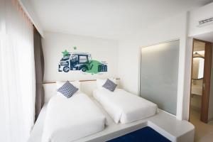 a bedroom with two beds and a truck sticker on the wall at Lub d Phuket Patong in Patong Beach