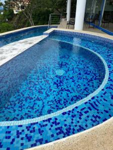 a swimming pool with blue tiles on top of it at Hermosa Heights Villa 58 in Playa Hermosa