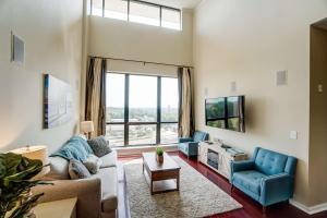 a living room with a couch and a tv at Luxury Uptown Penthouse in Charlotte