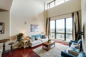 a living room with a couch and a large window at Luxury Uptown Penthouse in Charlotte