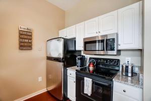 a kitchen with white cabinets and a stainless steel refrigerator at Luxury Uptown Penthouse in Charlotte