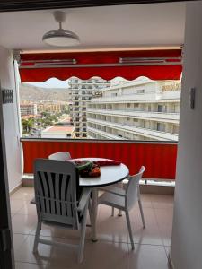 a table and chairs in a room with a large window at Tagora del Guayero in Los Cristianos