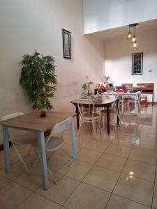 a dining room with tables and chairs and a potted plant at Rumah Bapak in Yogyakarta