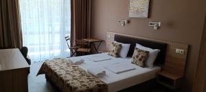 a bedroom with a large bed with white sheets and pillows at Апартаменти Детелини in Primorsko