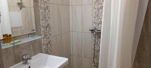 a bathroom with a sink and a mirror at Апартаменти Детелини in Primorsko