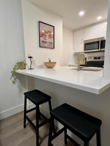 a kitchen with a counter and two black stools at Highview Studio in Vancouver +48 photos