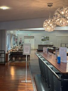 a restaurant with tables and a sign in a room at Kraatterin Helmi Suite Resort Premium-Luxus 1107 in Lappajärvi