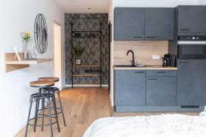 a kitchen with gray cabinets and stools in a room at Station 21 - Luxus Lofts - Gruppen bis 20 Personen - Parkplatz - Konferenzraum in Fulda