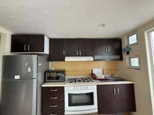 a kitchen with a stove and a refrigerator at Private House in Secure Complex with Pool & Lush Garden in Cuautlixco
