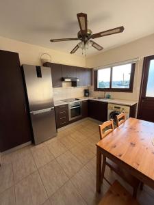 a kitchen with a table and a ceiling fan at Pervolia appartment in Kiti