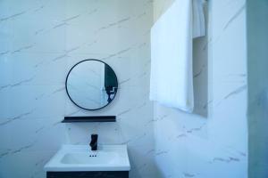 a bathroom with a sink and a mirror at Cozy 3BR Stay & Free Parking in Dodoma