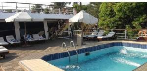 Una piscina con sillas y sombrillas al lado de una casa. en ريفر بوت - نايل كروز, en El Cairo