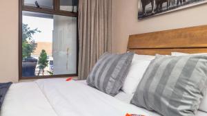 a bedroom with a white bed with pillows and a window at Sandi-Lee's Casa Bella in Plettenberg Bay +29 photos
