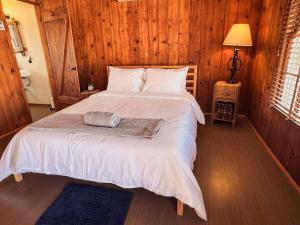 a bedroom with a large bed with a wooden wall at Room 4 - Downtown Joshua Tree Motel - Pet Friendly - Walk to Shops & Visitor Center, Minutes to Park Entrance in Joshua Tree