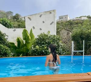 a woman sitting in the water in a swimming pool at Finca La Sirena Habitaciónes in Garachico
