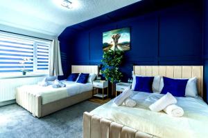 En eller flere senge i et værelse på Blue Haven House Sleeps 11 Garden & Parking