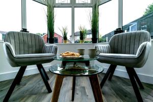 two chairs and a coffee table in a room at Blue Haven House Sleeps 11 Garden & Parking in Orgreave