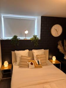 a bedroom with a large bed with a clock on the wall at Studios Louis RICARD in Rouen +16 photos