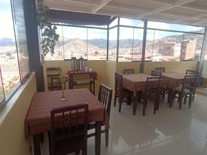 a restaurant with tables and chairs and large windows at Marlon's INN Cusco II in San Antonio +42 photos