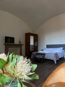 a bedroom with a bed and a table with flowers at Palazzo Cagianelli in Perugia