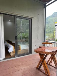 a room with a bed and a table on a deck at Trúc Nhân Hotel in Dồng Văn