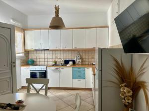a kitchen with white cabinets and a table at Mare Monte Suites 1 in Parasporos