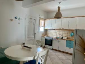 a kitchen with a white table and a table and chairs at Mare Monte Suites 1 in Parasporos +28 photos