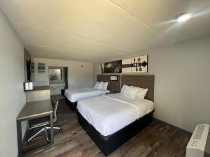 una habitación de hotel con dos camas y un escritorio en Westowne Inn Paducah I-24 Exit 4, en Paducah