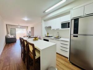 a kitchen with a white counter and a refrigerator at Residencial Larissa - Apartamento na Praia de Palmas - 2 Dormitórios até 6 pessoas in Governador Celso Ramos