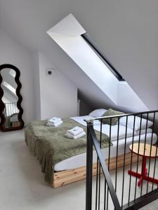 a bedroom with a bed in a attic at Apartament WHITE GLOVE PARKYA LOFT in Olsztyn