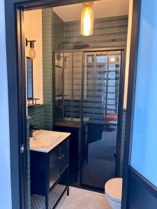 a bathroom with a sink and a glass shower at Apartament WHITE GLOVE PARKYA LOFT in Olsztyn