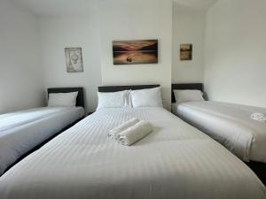 Dos camas en una habitación con sábanas blancas. en The LFC Red House - Spacious House With 5 Bedrooms, 2 Bathrooms, Street Parking And 1 Minute From The Stadium, en Liverpool