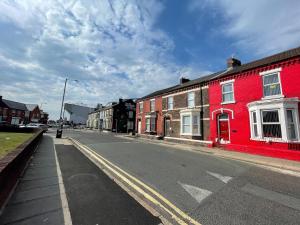 un edificio rojo al costado de una calle en The LFC Red House - Spacious House With 5 Bedrooms, 2 Bathrooms, Street Parking And 1 Minute From The Stadium, en Liverpool