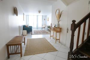 ein Wohnzimmer mit einem blauen Sofa und einem Tisch in der Unterkunft Nest - Maison Rénovée, Parking gratuit, Fibre in Saintes