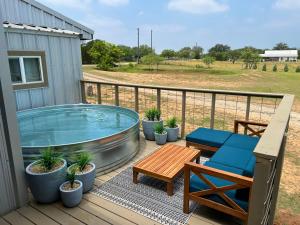 eine Terrasse mit einem Whirlpool, einem Tisch und Stühlen in der Unterkunft Hollmig Trio - Sleeps 18 Cowboy Pool & 3 Hot Tubs in Fredericksburg