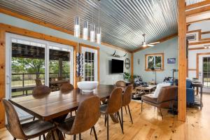 ein Esszimmer mit einem Holztisch und Stühlen in der Unterkunft Hollmig Trio - Sleeps 18 Cowboy Pool & 3 Hot Tubs in Fredericksburg