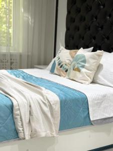 a bed with blue and white sheets and pillows at Laylak House in Salor Bekati