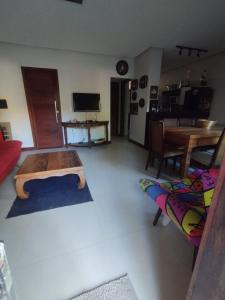 a living room with a bed and a table at Condomínio Conchas e Corais in Barra Grande