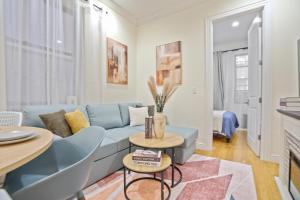 a living room with a blue couch and a table at Urban 2BR Comfort Unit near Central Park in New York +7 photos