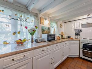 een keuken met witte kasten en een aanrechtblad bij 2 Bed in Brede 46895 in Brede +11 foto's